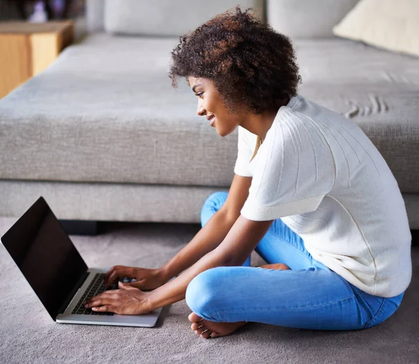 查看最新的Celeb新闻 一个年轻的女人坐在地板上 她的笔记本电脑在家里 — 图库照片