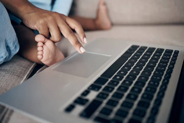 stock image Mama has magic in her fingers. an unrecognizable woman using a laptop with her daughter on the sofa at home