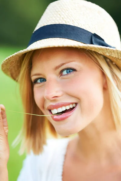 彼女は自然の美しさです 素敵な若い女性は 帽子をかぶっている間笑顔と小麦の茎を噛む — ストック写真