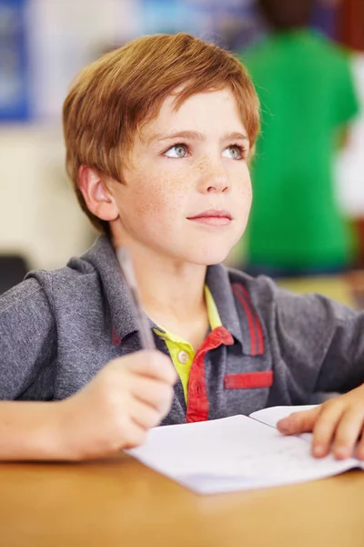 专心听他的老师讲话 一个可爱的小男孩在课堂上做作业 — 图库照片