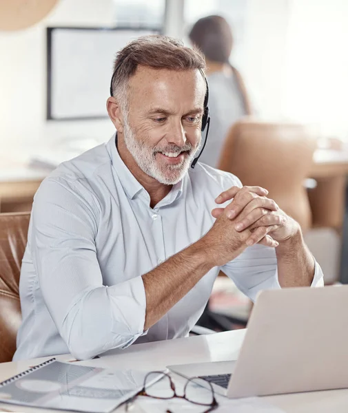 stock image Glad to hear youve had a good experience with us. a mature man using a headset and laptop in a modern office