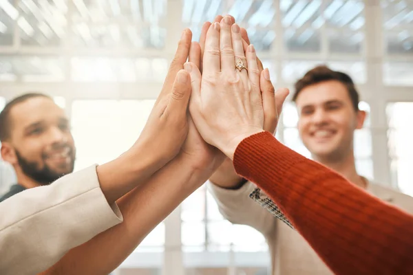Group of designers giving each other a high five. Businesspeople with their hands together. Businesspeople giving each other support and motivation. Architects united together.