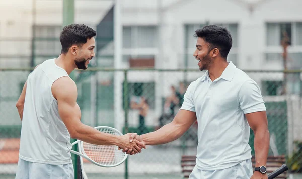 两名民族网球选手在进行宫廷比赛前握手 微笑的运动队站着 用手势和握手来表示好运 开展竞技体育比赛促进健康 — 图库照片