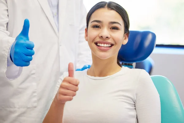 十分之十的牙齿 一位年轻女子在看牙医时竖起大拇指的画像 — 图库照片