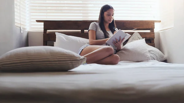 记日记是一个很好的洗脑方法 一个年轻的女人坐在床上 在家里写日记 — 图库照片