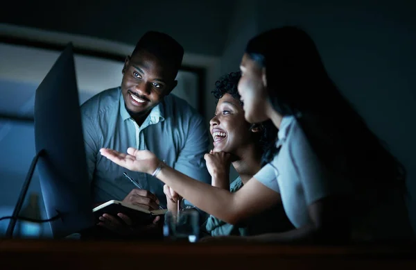 stock image Dedication is always well rewarded. a group of young businesspeople using a computer together during a late night at work