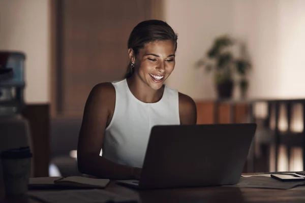 Hard work is the best kind of work. a young businesswoman using a laptop during a late night at work