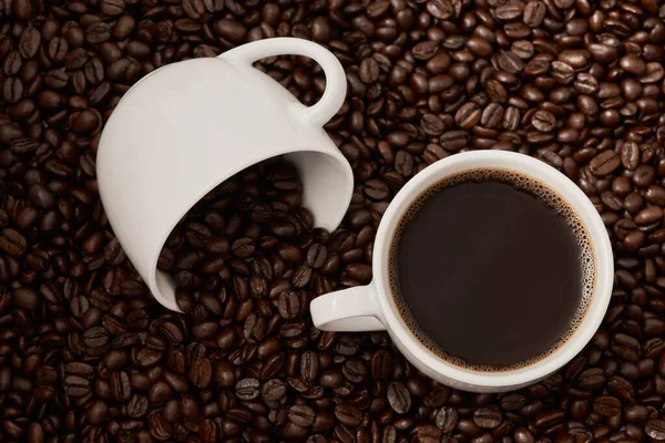 豆からカップへの旅 コーヒー豆に囲まれた2杯のコーヒーのクローズアップ — ストック写真
