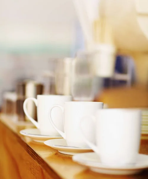 クローズアップ 紅茶やコーヒーマグカップや磁器のコレクション 背景モックアップ付きテーブルの上にプレートとカップ カフェ ホテルのおもてなしやレストランのための白 ガラスと朝食ケータリングサービスセット — ストック写真