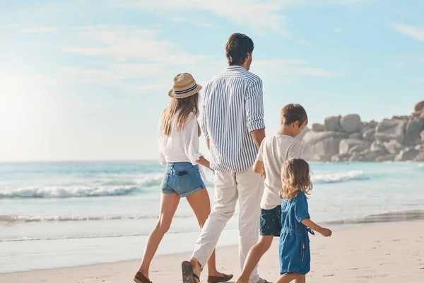 これは完璧な家族の絆の日です 2人の子供と手を携えてビーチを歩いている認識できないカップルのレビューショット — ストック写真