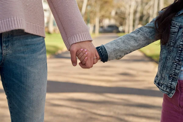 俺とママだけだ 公園を散歩しながら母親の手を握っている少女が — ストック写真