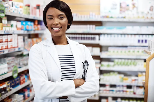 Her smile will make you feel better already. a female pharmacist working in a drugstore