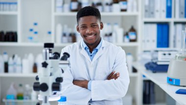 Ben buranın patronuyum. Bir laboratuarın içinde kolları bağlı duran neşeli genç bir bilim adamının portresi.