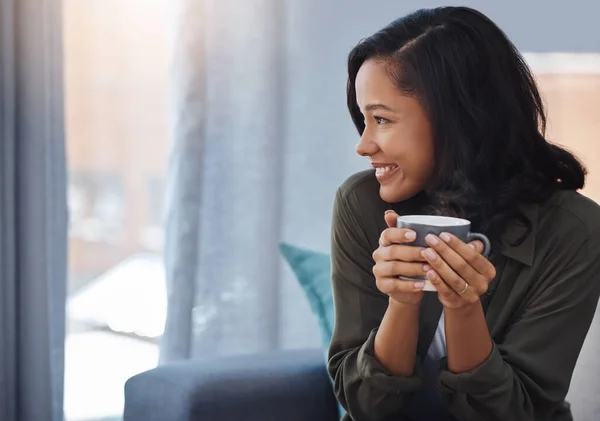 stock image The only thing to do today is relax. an attractive young woman having coffee and relaxing on the sofa at home