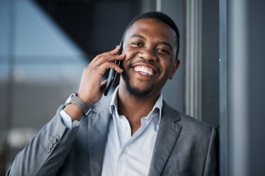 Müşterilerle güven inşa etmenin en iyi yoludur. Yakışıklı genç bir işadamı dışarıda tek başına duruyor ve gün içinde cep telefonunu kullanıyor.