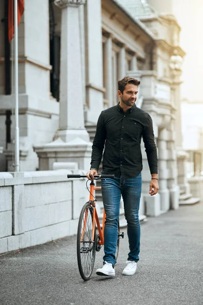 도시를 돌아다니는 자전거를 자전거를 도시를 여행하는 잘생긴 젊은이의 — 스톡 사진