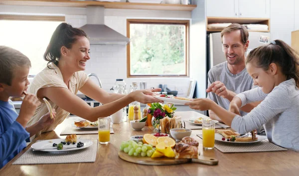 请自便 亲爱的 两个充满爱心的年轻父母在家里的厨房里和孩子们一起吃早餐 — 图库照片