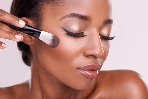 Cosmetic glow, makeup brush on face and black woman with skincare in  studio, cosmetics tool. Skin care, blush and foundation, African beauty  model Stock Photo - Alamy