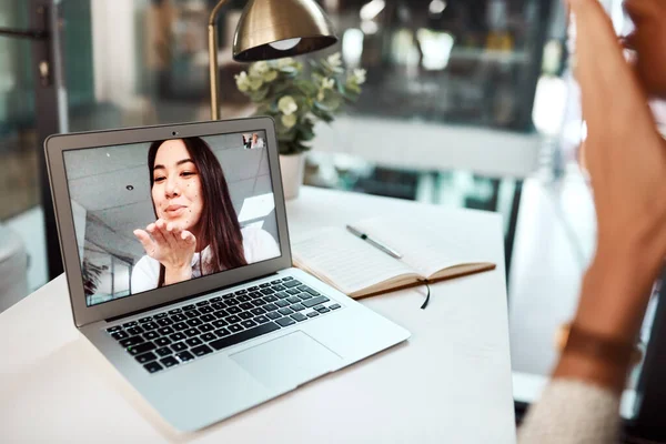 Ive been missing you. a young woman blowing a kiss while appearing on a laptop screen during a video call