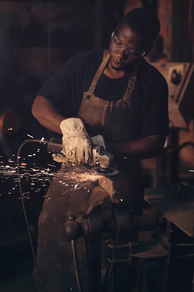 使用电动工具来完成动力 在铸造厂工作时使用角磨床的年轻人 — 图库照片