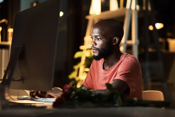 stock image All they need from you is dedication. a business man using his computer while working late at the office