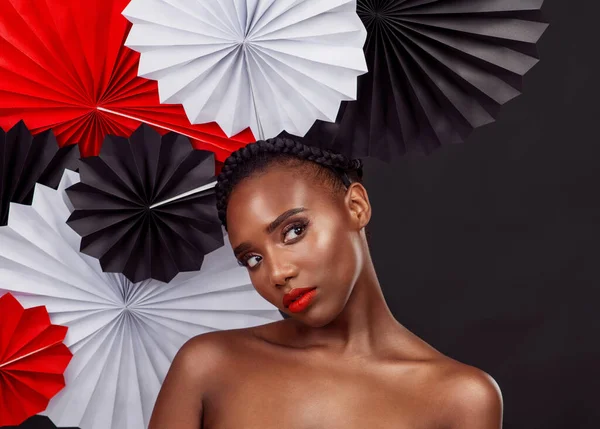 stock image Ill leave the less is more for another day. Studio shot of a beautiful young woman posing with a origami fans against a black background