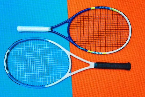 2人の誰かを選べ スタジオ内のカラフルな背景の上に配置されたテニス必需品の高角度ショット — ストック写真