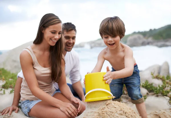 夏にビーチで家族 砂の城を楽しみ 旅行したり 笑顔で休日を過ごしましょう おもちゃのバケツと一緒に海で休暇で遊ぶ男と女と興奮した子供 開発と幸福 — ストック写真