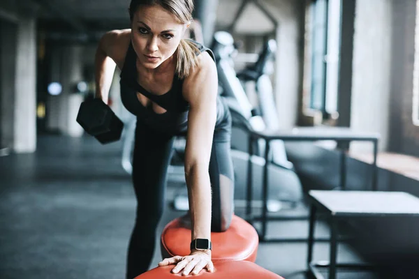 stock image Strong - a choice she makes everyday. a young woman working out with weights in a gym