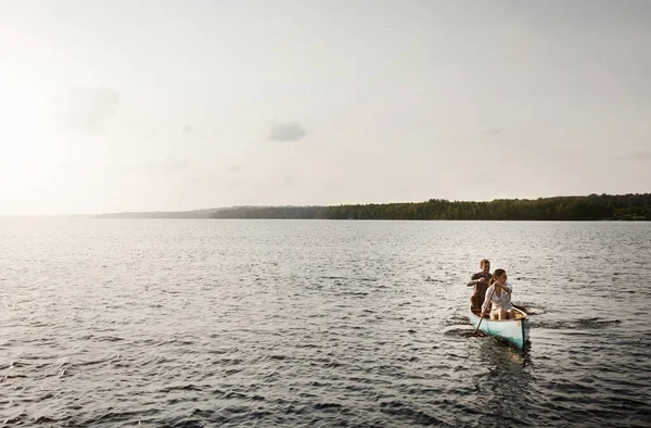 排成一排 再往前划 一对年轻夫妇在湖上划船 — 图库照片