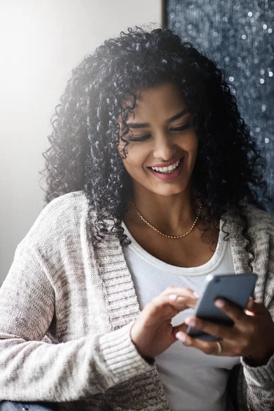 Jovem mulher sorrindo e rindo enquanto envia mensagens de texto em um  telefone em casa mulher alegre conversando com seus amigos com aplicativos  rolando mídias sociais e assistindo memes engraçados da internet enquanto  relaxa em um sofá