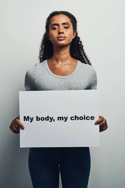 私は自分の体をどうするか選択する 私の体を読むプラカードを持っている魅力的な若い女性のスタジオショット 灰色の背景に対する私の選択 — ストック写真