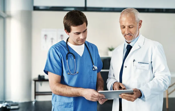 用数字方式监测健康 两名医生在医院使用数码平板电脑 — 图库照片