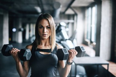 Tek rakibim benim. Spor salonunda ağırlık çalışan genç bir kadın.