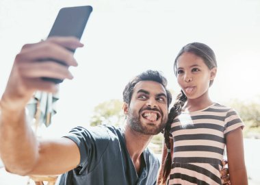 Bazıları onlara selfie diyor, onlar buna anı yapmak diyor. Bir baba ve kızı cep telefonuyla selfie çekiyorlar.