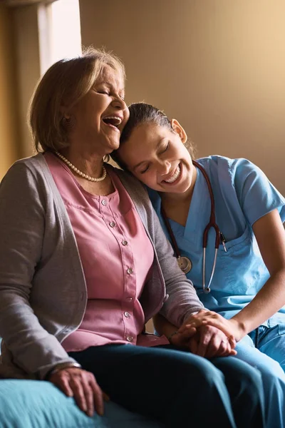 彼らはとても近くで育った 年配の患者とおしゃべりをしている女性看護師が — ストック写真
