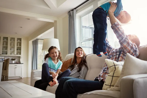 最も意味する人々のための時間を作りなさい 4人組の幸せな若い家族が自宅のソファで — ストック写真