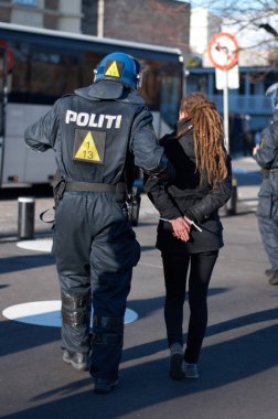 Polis memuru şehirde protesto yapan kadını tutukladı, suç ve kolluk kuvvetleri, sokaktaki gösteride güvenlik. Etkinlikte güvenlik için kamu görevlisi, hizmet ve devriye, aktivist ve memur arka görüşü.