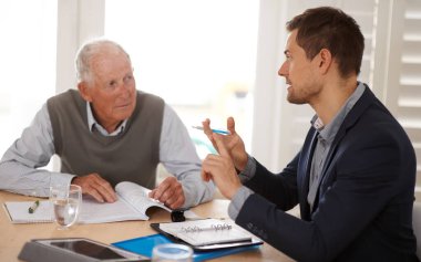 Yatırım, tasarruf ya da emeklilik planıyla kıdemli bir adamla konuşan mali danışman. Tartışma, belgeler ve profesyonel muhasebeci yaşlı bir erkeğe mali evrak işlerinde yardım ediyor.