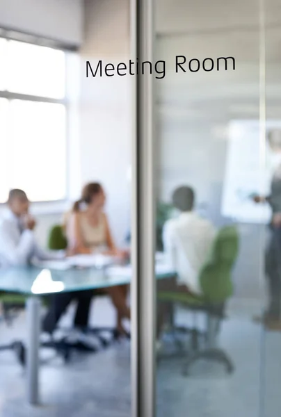 Boardroom, business and team collaboration in a meeting room with company and office glass sign. Management, presentation and conference in the workplace with a workshop and teamwork planning