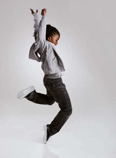 Talent, hip hop and young boy dancer dancing isolated in a white studio background in a pose feeling excited. African, urban and kid or child with energy and skill ready for breakdance performance.
