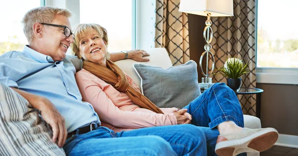 快適さで引退 成熟した夫婦が自宅のソファでリラックスして — ストック写真