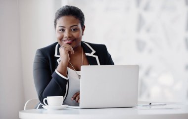 İş yapmanın doğru bir yolu yok. Ofiste dizüstü bilgisayarı üzerinde çalışırken düşünceli görünen çekici bir genç kadının kesilmiş portresi.