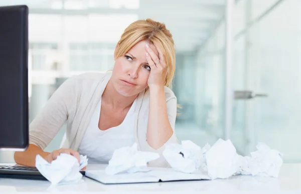 Stress, thinking and frustrated woman with crumpled papers on her desk in business office. Burnout, idea and female professional with lack of creativity, depression and fatigue, tired and brain fog