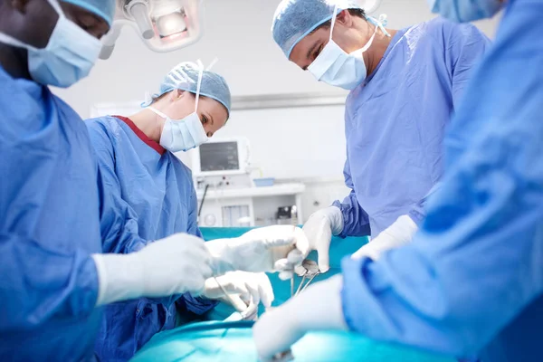 長年の経験から安定した手 手術中の患者に作用する医療外科医の側面図 — ストック写真