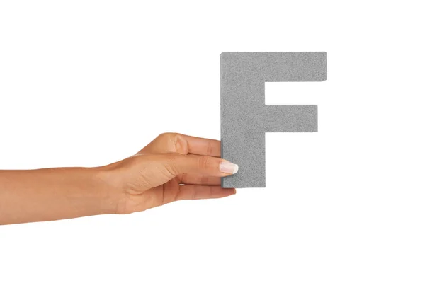 这是字母F 一个年轻女人拿着一个大写字母F 与白色背景隔离 — 图库照片