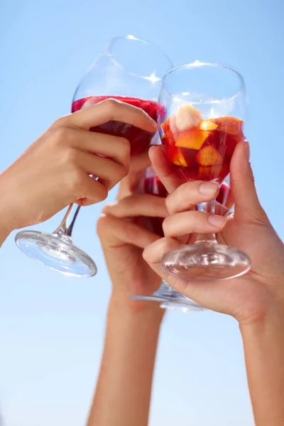 Hands, cocktail toast and friends outdoor for celebration of friendship together. Alcohol, glass and group cheers to celebrate at summer party, event or social gathering for drinking in low angle