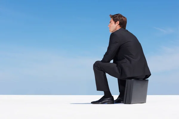 Προσεκτικός Επιχειρηματίας Που Κάθεται Πάνω Χαρτοφύλακα Στον Γαλάζιο Ουρανό Προνοητικός — Φωτογραφία Αρχείου