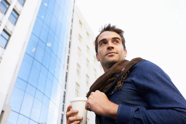 咖啡在跑 一个英俊男子一边喝咖啡一边在城里走来走去的低角度镜头 — 图库照片