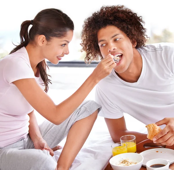 一日を始めるための健康的な方法 幸せな若いカップルがベッドで朝食を共にし — ストック写真